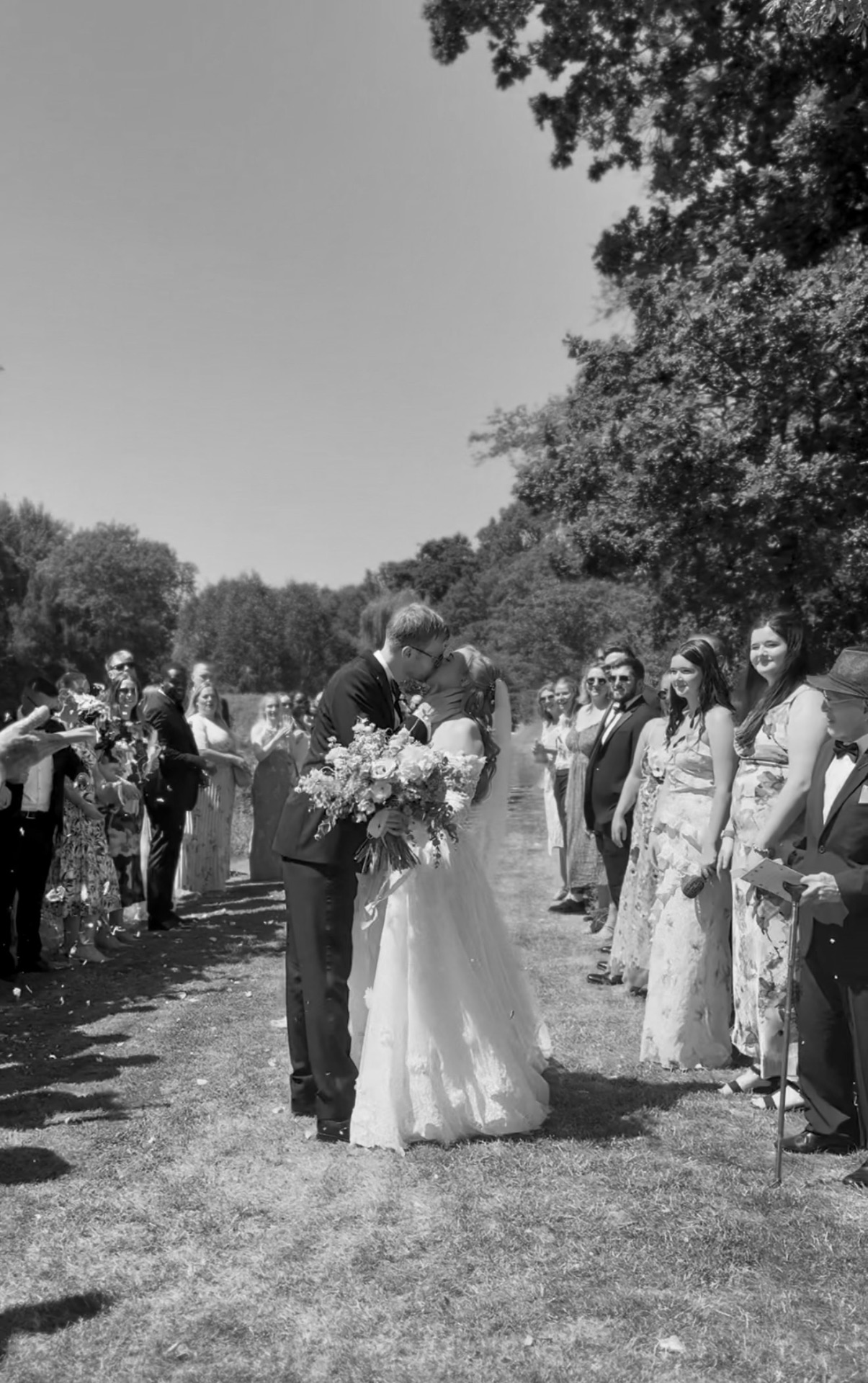 Confetti aisle kiss with guests cheering